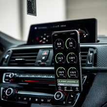 Load image into Gallery viewer, Mobile device mounted in car showing JB4 Bluetooth connect kit app interface by Burger Motorsports
